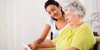 A woman and an older person looking at something on the screen.
